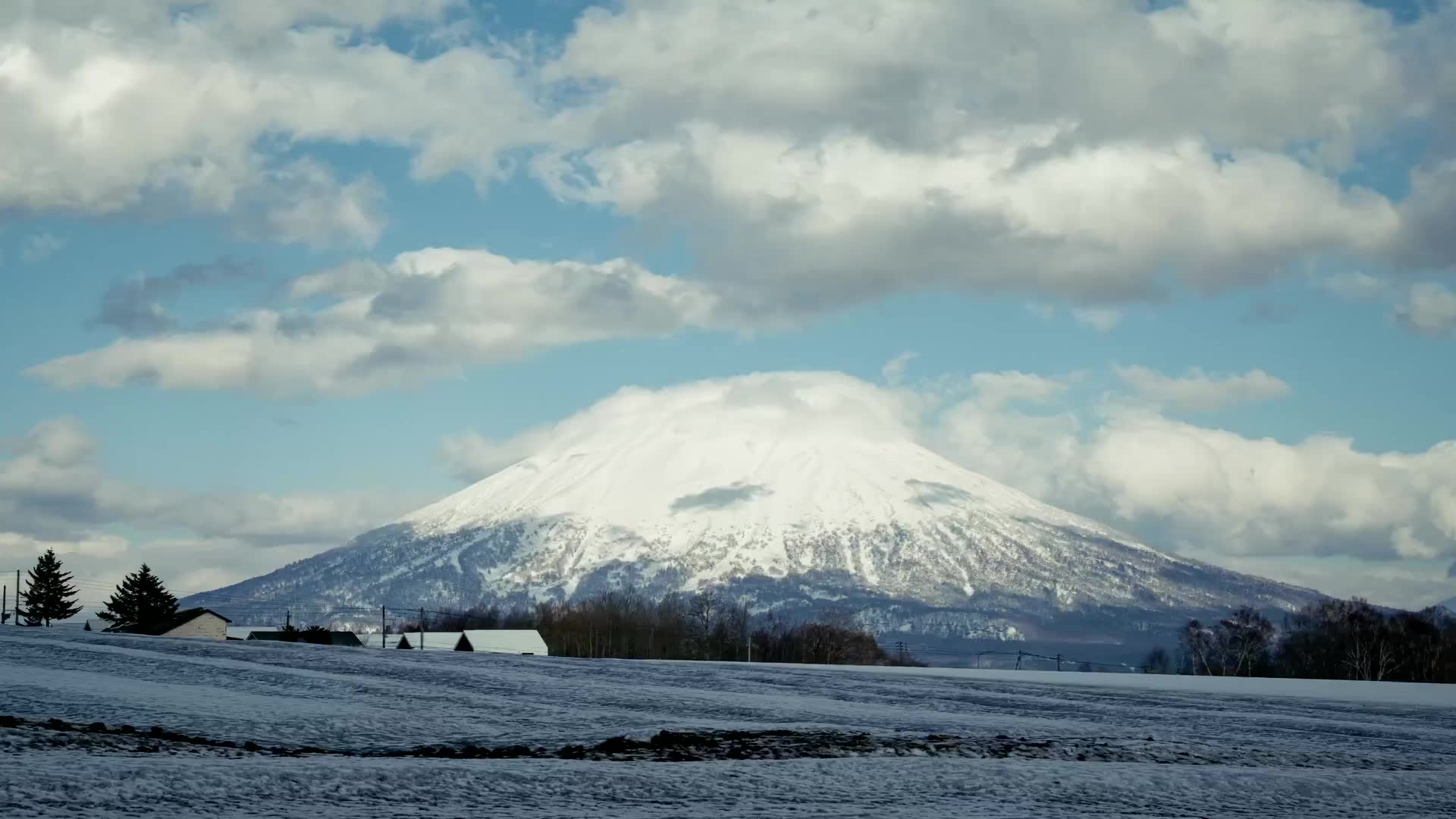 Mount Yotei under deep snow, rising over the fields of the Niseko valley in Hokkaido